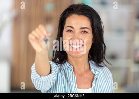 happy older woman showing key Stock Photo