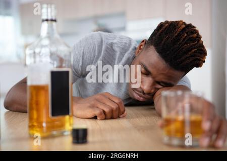 alcohol addicted man sleeping at the table Stock Photo