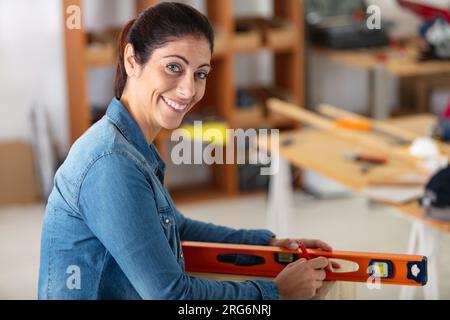 young woman using spirit level at workplace Stock Photo