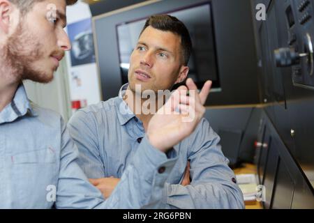 factory manager and engineering apprentice talking Stock Photo