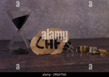 Wooden cubes with the inscription CHF and a cube symbolizing the rise and fall of financial markets. Stock Photo
