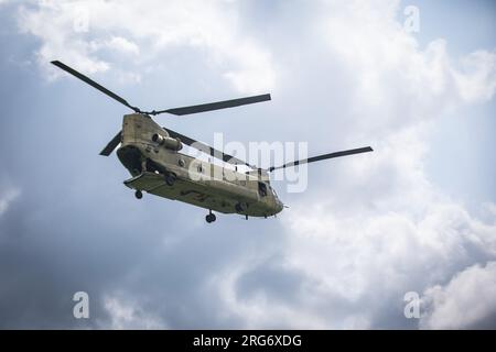 A CH-47 Chinook helicopter flies by Glen Rock Drop Zone at Exeter, Rhode Island, August 5, 2023. Leapfest is the largest, longest standing, international static line parachute training event and competition hosted by the 56th Troop Command, Rhode Island Army National Guard to promote high level technical training and esprit de corps within the International Airborne community. (U.S. Army Reserve photo by Sgt. Eric Kestner) Stock Photo