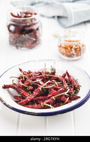 Red chili peppers in the bowl on white table. Stock Photo