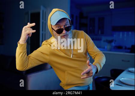 Funky senior man in modern casual clothes dancing for camera Stock Photo