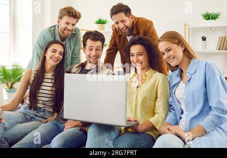 Group of friends enjoy spending time together watching comedy movie on laptop. Stock Photo