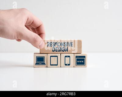 Responsive design concept. Web design. Hand places wooden block with the word responsive design with technology symbols. Stock Photo