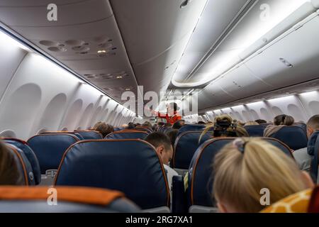 Beautiful flight attendants explain to passengers how to use Stock Photo