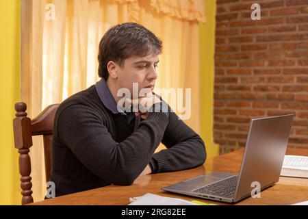 Concentrated boy studying in front of a laptop. Stock Photo