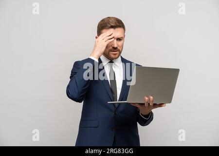 Frustrated trader man with laptop in hands. Business collapse, difficulties, financial problems Stock Photo