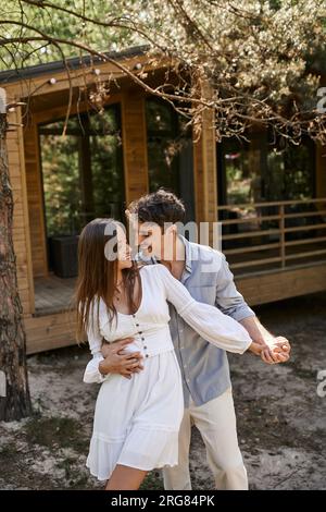 happiness and laughter, man hugging woman near vacation house, in ...