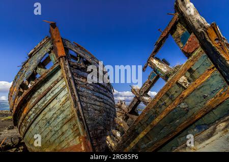 Old wooden fishing boats wrecked at the side of the sea, Isle of Mull Stock Photo