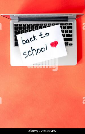 Laptop and a piece of paper with the inscription Back to school. Stock Photo