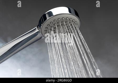 Chrome silver shower head with running water on a bathroom. Water Running from the shower. #shower Stock Photo