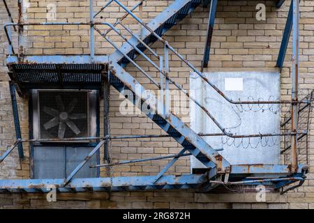 Close up on blue metal fire escape steps on outside of old warehouse building in Bradford, England, UK. Stock Photo