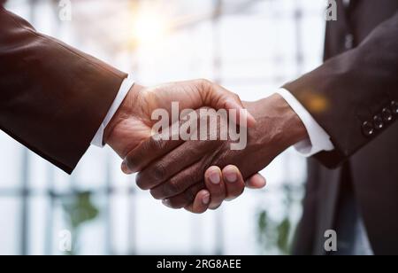 Businessmen reach out to each other to shake hands Stock Photo