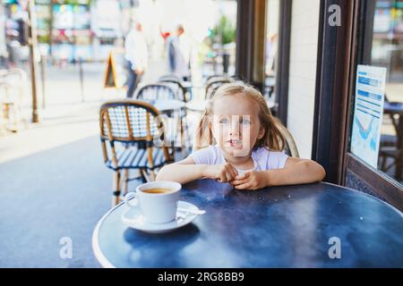 Adorable three year old girl in Parisian cafe or restaurant. Going out with kids concept Stock Photo