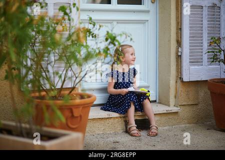 Adorable preschooler girl walking on a street of Medieval village of Lourmarin in Provence, Southern France Stock Photo