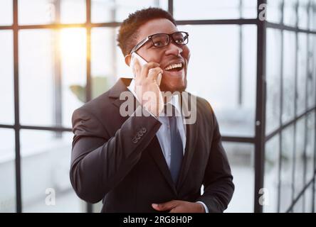 Good connection. Young african guy talking by cell phone and smiling Stock Photo