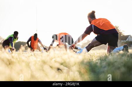 Rugby, team and group stretching at training for match or competition in the morning doing warm up exercise on grass. Wellness, teamwork and people or Stock Photo