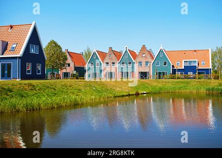 Colorful houses reflected in water in marine park in Volendam. Typical Dutch landscape in North Holland, the Netherlands. Stock Photo