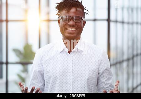 Portrait of handsome young smiling man in suit asking to make a choice between two products on his palms Stock Photo