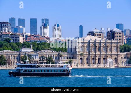 Istanbul, Turkey, Türkiye. Tourist Boat Passing by the Dolmabahce Palace as Seen from the Bosphorus. Stock Photo