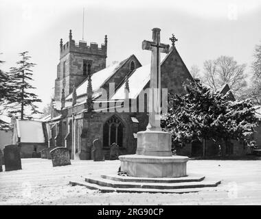Winter snow scene - the War Memorial Cross and the Church of St. John the Baptist, at Claines, near Worcester, Worcestershire, England. Stock Photo
