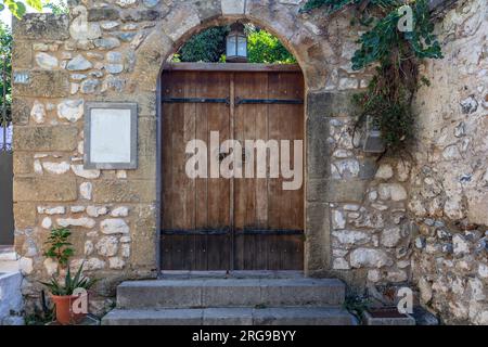 wooden door in a stone archway with greenery Stock Photo