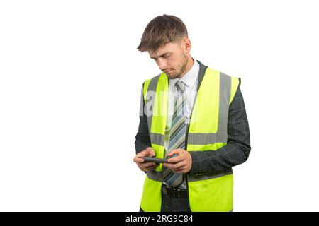 Portrait of a business man in a suit, with a hi-vis vest reading messages on a mobile phone Stock Photo
