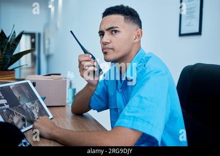 Walkie talkie, security guard and man at table in communication, surveillance and thinking. Safety, protection and serious officer on radio at desk to Stock Photo