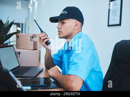 Walkie talkie, security guard and man at table in surveillance, communication in an office. Safety, protection and serious officer on radio at desk to Stock Photo