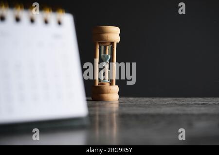 Close up image of calendar and hourglass with copy space. Deadline, time limit and period concept. Stock Photo