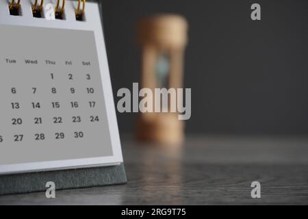 Close up image of calendar and hourglass with copy space. Deadline, time limit and period concept. Stock Photo