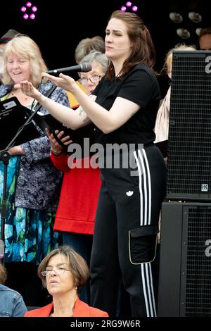A woman signing for the deaf alongside a choir. Stock Photo