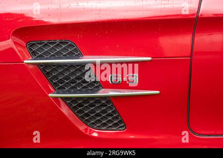 A close-up of the left side panel showing the air vent and 6.3 lettering on a red Mercedes SLS AMG German sports car Stock Photo