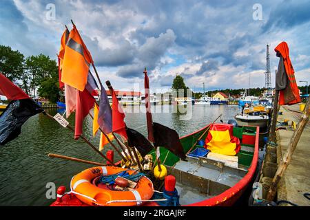 Fishing boat with trap flags in Rybacka harbor on the Curonian Lagoon in Poland Stock Photo