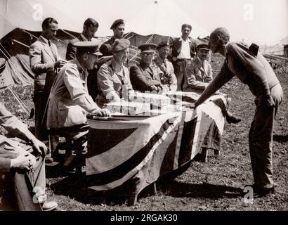 1943 Middle East Syria - scene at Aleppo - British army recruits - recruit taking oath on the Koran Photograph by a British army recruitment officer stationed in East Africa and the Middle East during World War II Stock Photo