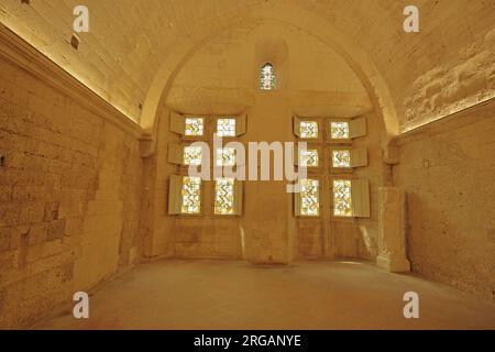 Interior view with stained glass window and figure of the Romanesque Cloître St-Trophime monastery church, Arles, Bouches-du-Rhône, Camargue, Provence Stock Photo