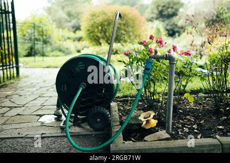 Top view of garden hose for watering. blue and black hose lies on concrete platform. Stock Photo