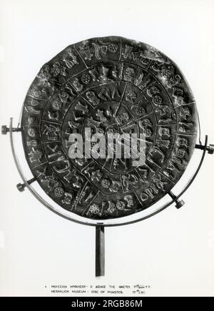 The Phaistos Disc (also spelled Phaistos Disk, Phaestos Disc) is a disk of fired clay from the Minoan palace of Phaistos on the island of Crete, possibly dating to the middle or late Minoan Bronze Age (second millennium BC). The disk is about 15 cm (5.9 in) in diameter and covered on both sides with a spiral of stamped symbols. The Phaistos Disc was discovered in the Minoan palace-site of Phaistos, near Hagia Triada, on the south coast of Crete. Stock Photo