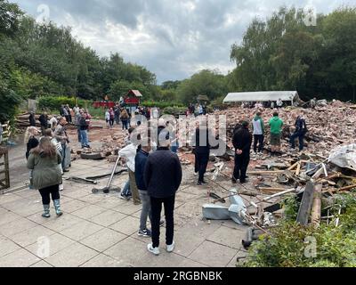 People inspect the rubble remains as they gather at The Crooked House pub in Himley, near Dudley in the West Midlands, which has been demolished two days after it was gutted by fire. Picture date: Tuesday August 8, 2023. Stock Photo