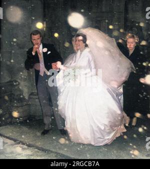 Lady Pamela Mountbatten (born 1929), younger daughter of Lord Louis Mountbatten, emerging with her groom, David Hicks (1929 - 1998) from Romsey Abbey during a snowstorm on their wedding day, 13th January 1960. Stock Photo