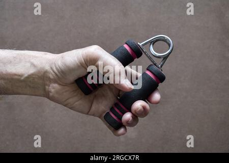 Hand of Southeast asian, Chinese old man gripping hand exercise gripper. Stock Photo