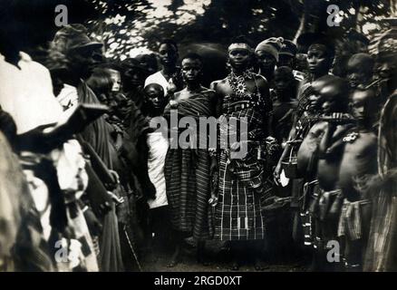 Ghana - Large group at a Funeral - One of the Women Chiefs, according to whoever wrote on the reverse of this print: 'the jolliest woman in Africa - she has promised to find me five young women if I will marry them - I fear going to visit her for fear she will produce them anytime - I would have to run then, wouldn't I  - not 'arf!' Stock Photo