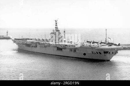 Royal Navy - HMS Ocean (R68), a Royal Navy Colossus-class light fleet aircraft carrier, seen departing Valletta harbour in May 1948, with ship's crew, Fireflies and Seafires ranged on deck. Stock Photo