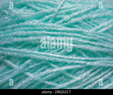 Macro texture of woolen turquoise thread, close-up, copy space. Macro Photography of a coil with threads. Sewing background, screensaver. Abstraction, Stock Photo