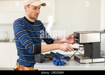 professional young worker fixing coffee machine Stock Photo