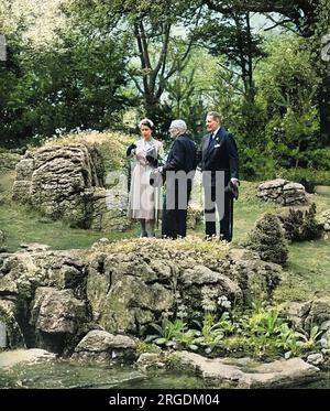 Queen Elizabeth II visiting the Chelsea Flower Show in 1955, inspecting a rock garden feature that has taken her attention.  She is conducted around the show by her maternal uncle, the Hon. David Bowes-Lyon. Stock Photo