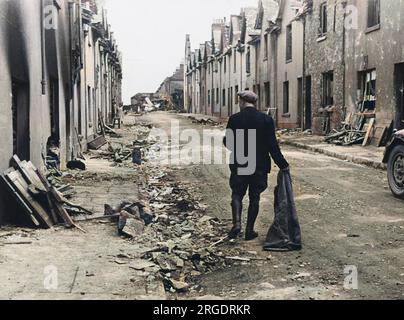 The morning after the raid - Plymouth. Mr Widdicombe walks through the bombed streets to salvage what he can of his belongings. Stock Photo