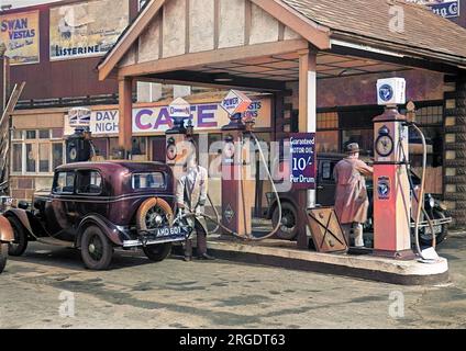 Scene at a petrol station, with an attendant filling up a car. Stock Photo